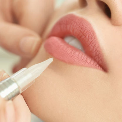 Ein Lippenpflegeprodukt wird mit einem feinen Stift auf die Lippen aufgetragen.